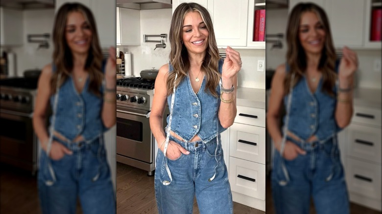 Sabrina Soto portant un gilet en jean et un jean avec un mètre ruban autour du cou posant dans une cuisine.