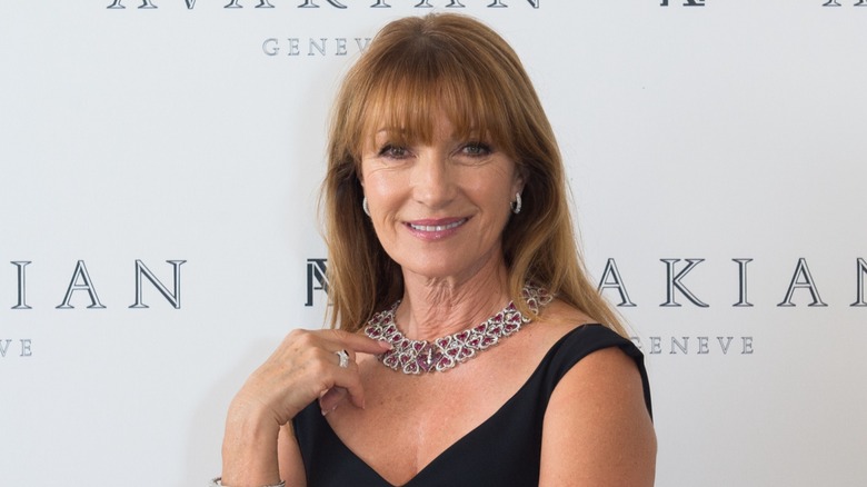 Jane Seymour lors d'un événement sur le tapis rouge, vêtue d'une robe noire avec un collier tendance et de délicates boucles d'oreilles.
