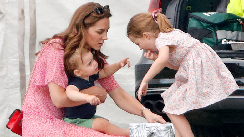 La princesse Charlotte prend une collation dans une glacière auprès de sa mère, Kate Middleton, et de son frère, le prince Louis