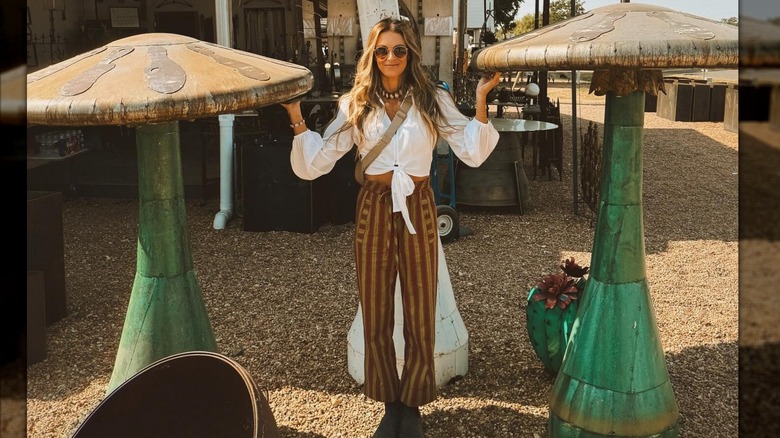 Chelsea Meissner debout à côté de sculptures de champignons