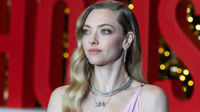 Amanda Seyfried regarde vers la gauche avec deux colliers ras du cou en cristal et des créoles