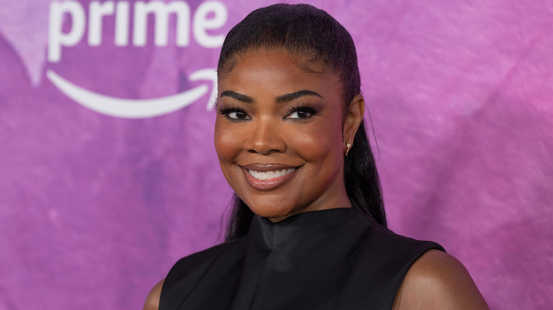 Gabrielle Union sourit en portant un haut noir à col montant