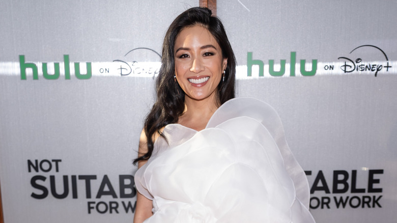 Constance Wu portant une robe blanche et maquillée