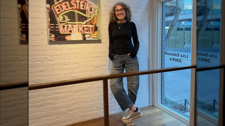 Lisa Edelstein à côté d'une enseigne au néon d'Edelstein's Market en mars 2026