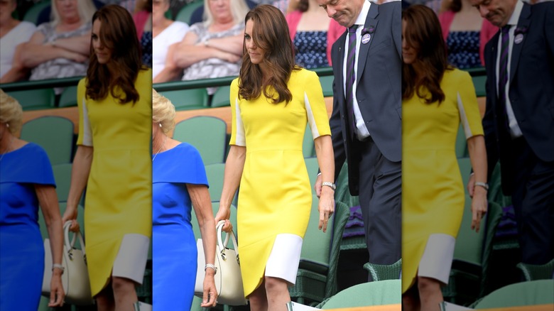 Kate Middleton portait une robe jaune avec des touches de blanc et un sac à main blanc à Wimbledon en 2016.