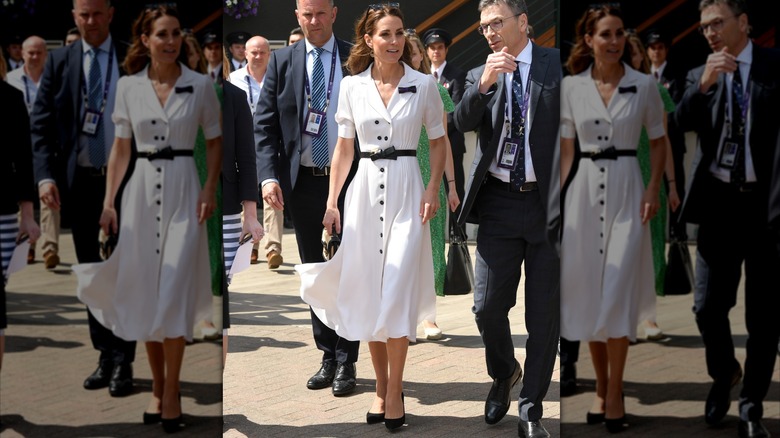 Kate Middleton portant une robe blanche avec des boutons noirs et une ceinture noire à Wimbledon en 2019.