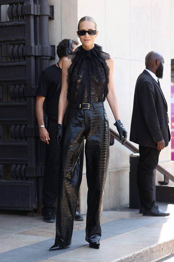 Poppy Delevingne arrive au défilé Elie Saab Haute Couture avec un pantalon en cuir et un haut en dentelle.