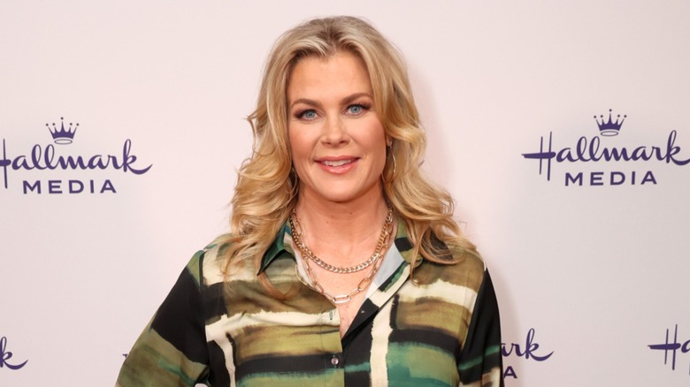 Alison Sweeney porte un chemisier à col vert et noir avec ses cheveux blonds ondulés lors de la session Hallmark Media du TCA Winter Press Tour à Pasadena en février 2024.