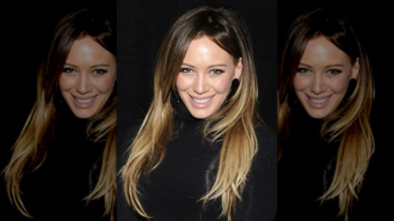 Hilary Duff souriante portant un haut noir en 2011
