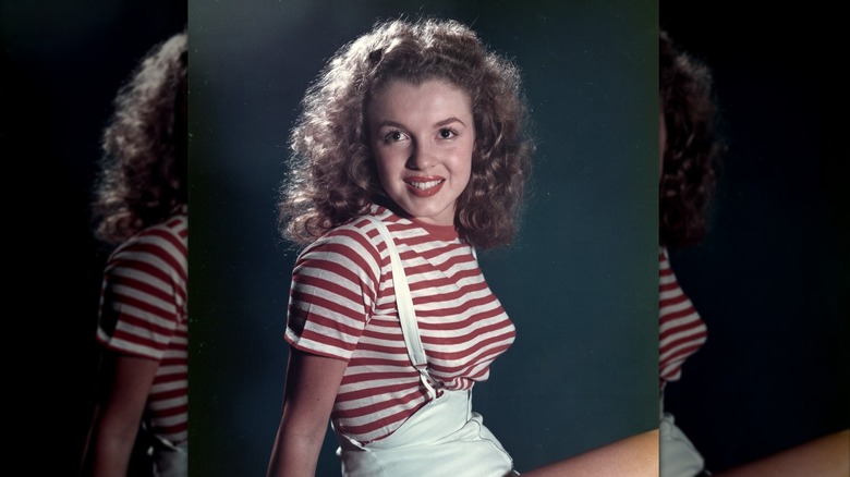 Marilyn Monroe posant en 1947 portant une chemise rayée rouge et blanche et un short à bretelles blanc.