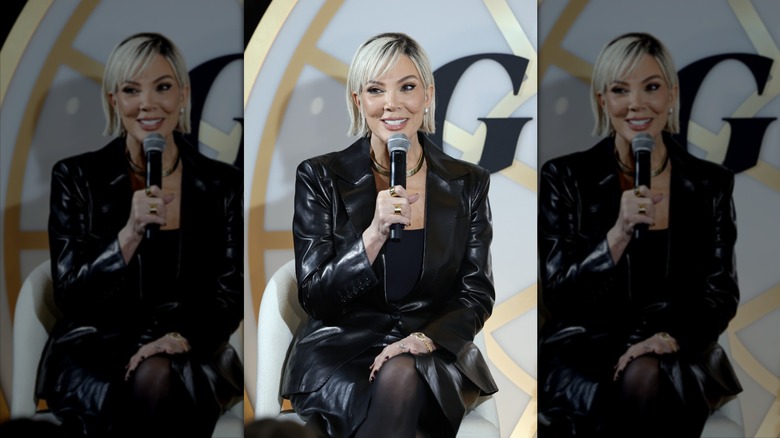 Kris Jenner sourit derrière un micro avec un carré blond