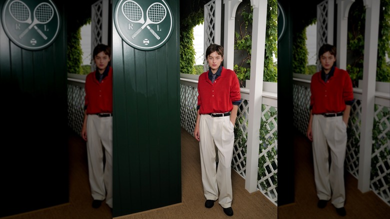 Emma Corrin porte un polo ample et une cravate avec un pantalon de costume blanc pour Wimbledon 2026