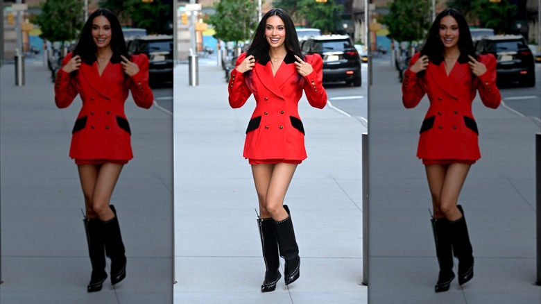 Kylie Cantrall porte un blazer rouge avec des épaulettes et une mini-jupe.