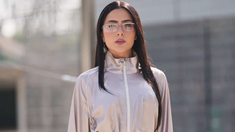 Une femme avec une coiffure droite et élégante et des lunettes