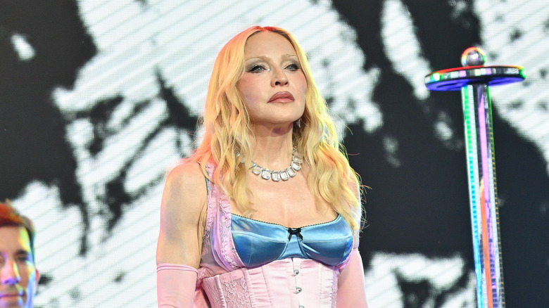 Madonna pose sur scène dans un haut corset rose et bleu