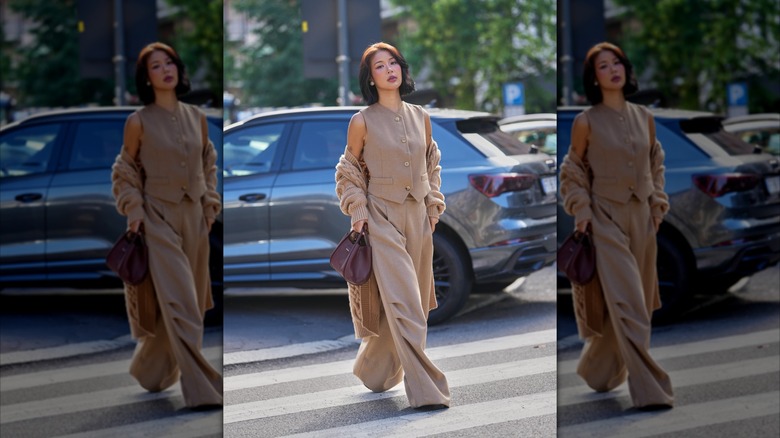 Une femme portant un pantalon kaki et un gilet long boutonné.