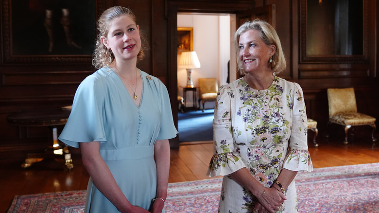 Lady Louise porte un lob bouclé et une robe bleue photographiée avec la duchesse Sophie dans une robe à fleurs blanche