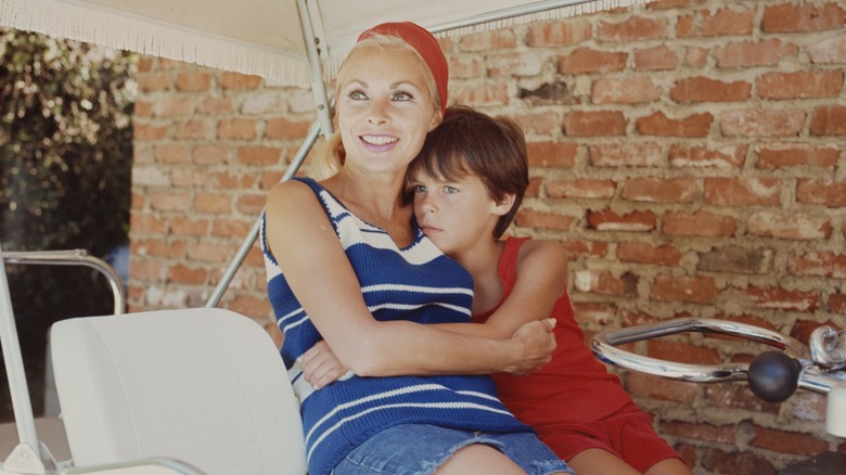 Janet Leigh portant un haut rayé bleu et blanc et un short en jean avec un bandeau rouge avec sa fille Jamie Lee Curtis portant une tenue rouge en 1967.