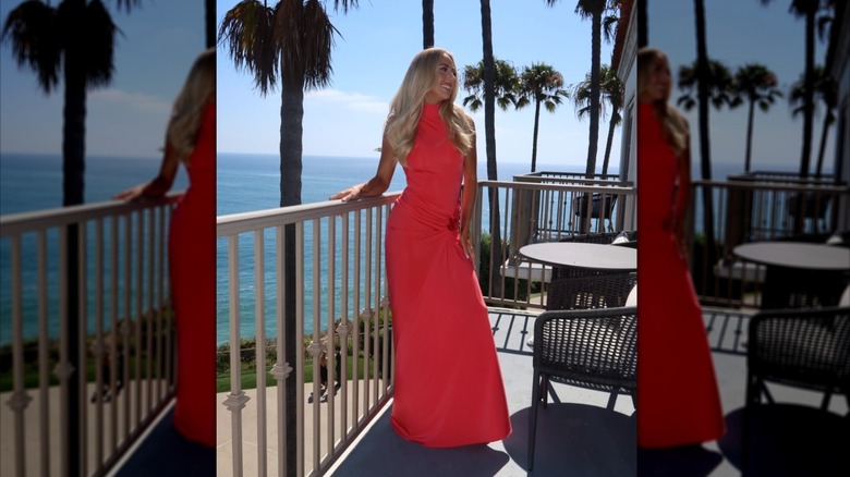 Brittany Mahomes pose sur un balcon dans une robe longue corail.