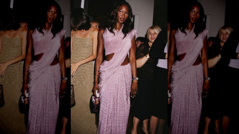 Naomi Campbell porte une robe drapée violet clair.