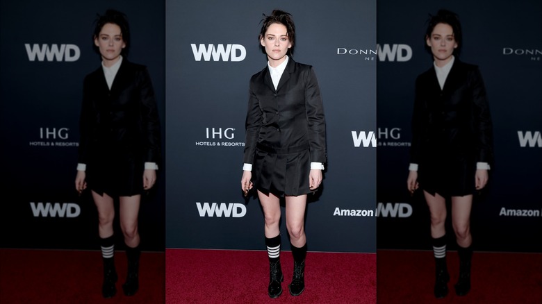 Kristen Stewart porte une robe veste noire avec des chaussures noires lors d'un événement sur le tapis rouge.