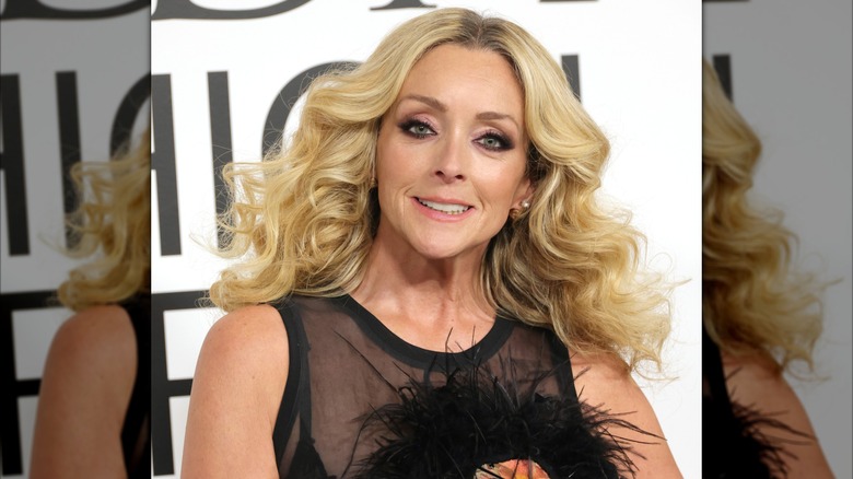 Jane Krakowski avec un haut noir translucide et de longues boucles coiffées