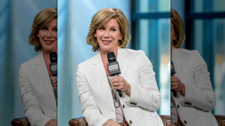 Melissa Gilbert parle dans un micro vêtue d'un blazer blanc