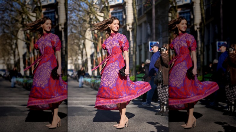 Une femme vêtue d'une robe à fleurs rose avec des talons nude