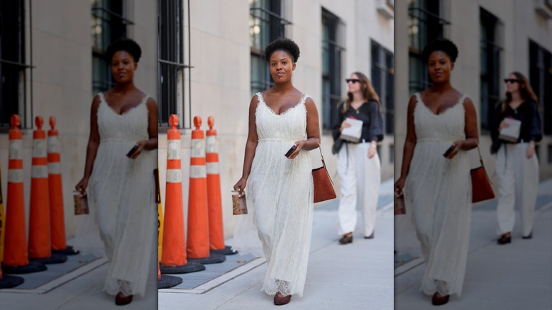 Une femme avec une robe en dentelle blanche à taille empire