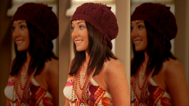 Lily Aldrin sourit avec un bonnet bordeaux