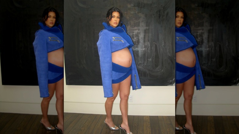 Kourtney Kardashian dans une tenue bleue deux pièces qui montre son ventre