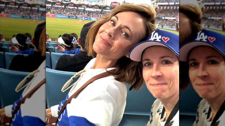Nikki DeLoach posant pour un selfie avec son amie Aimee Parker, toutes deux vêtues de vêtements de sport, assistant à un match de baseball.