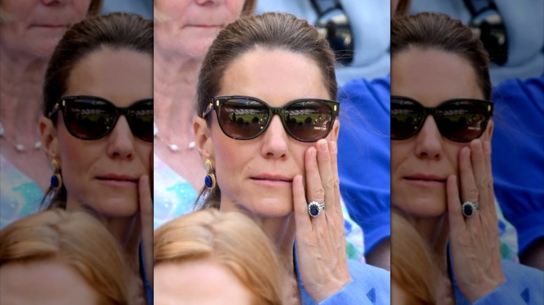 Kate Middleton porte des lunettes de soleil avec la main sur la joue à Wimbledon 2026.