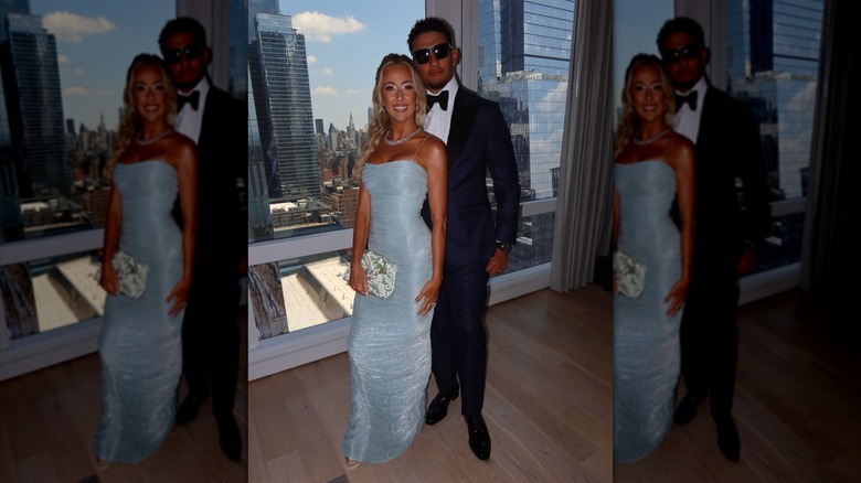 Brittany Mahomes et Patrick Mahomes posent ensemble devant une fenêtre donnant sur les toits de New York.