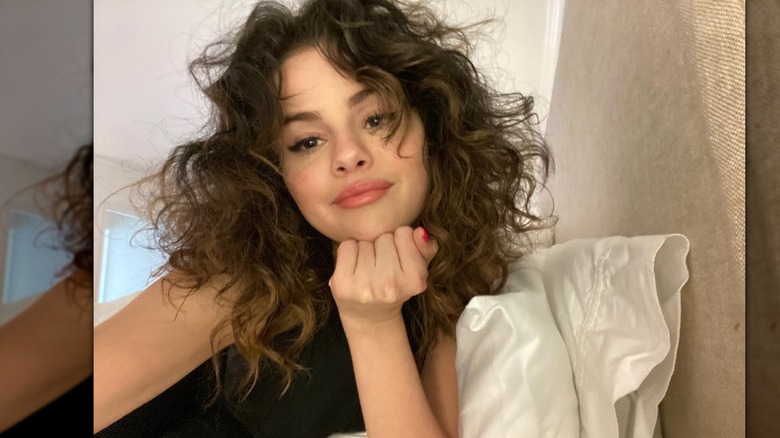 Selena Gomez sourit dans un selfie au lit