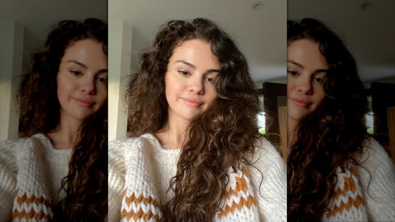 Selena Gomez sourit dans un pull en tricot
