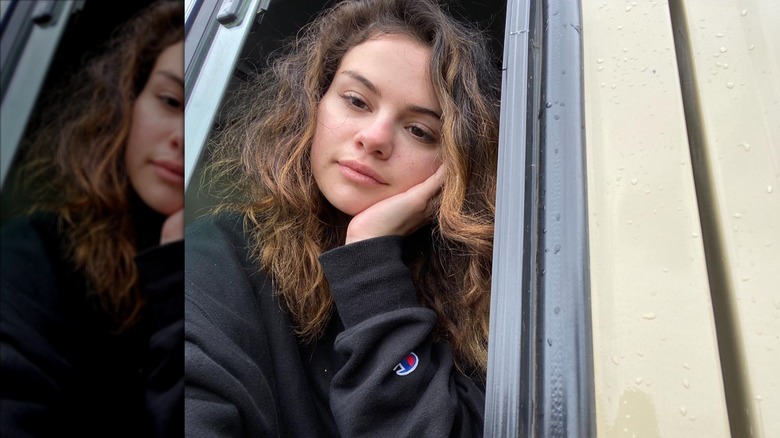Selena Gomez pose pour une photo près d'une fenêtre