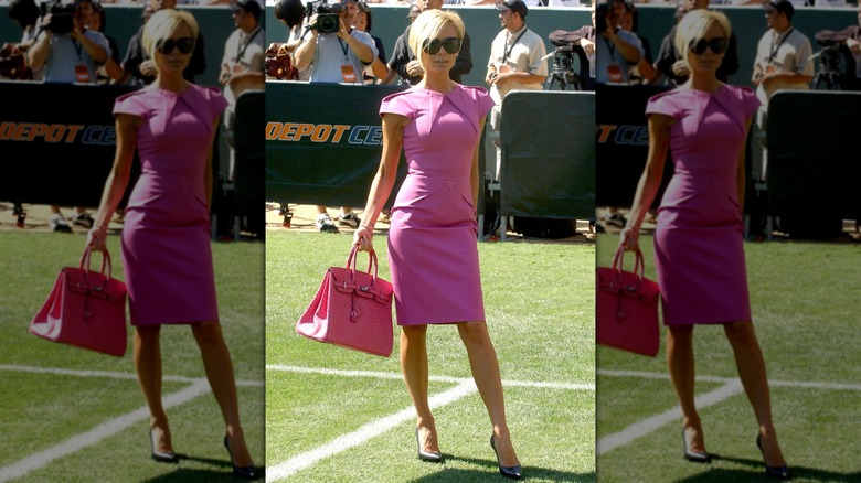 Victoria Beckham dans une robe rose avec un sac Hermès