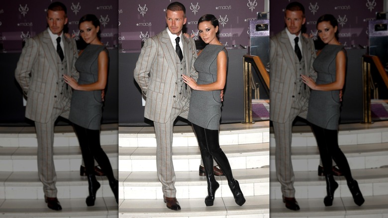 Victoria Beckham en robe grise et bottes avec David Beckham