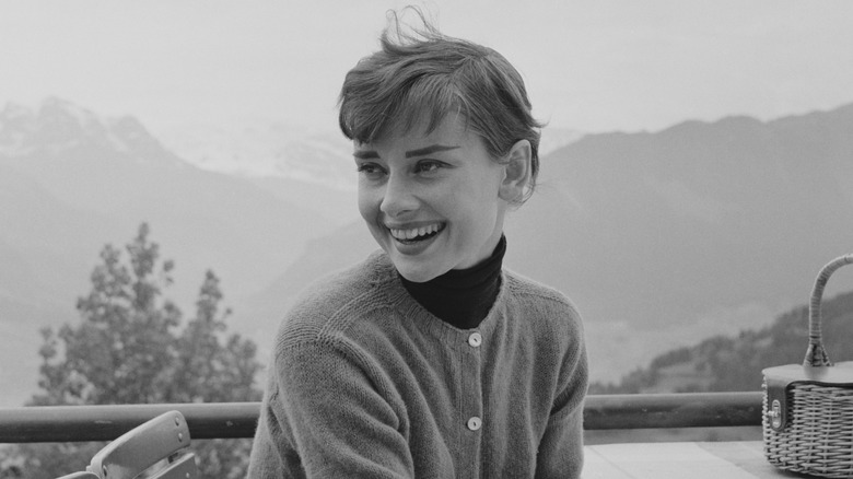 Photo en noir et blanc d'Audrey Hepburn dans un restaurant au sommet d'une montagne en Suisse en 1955.
