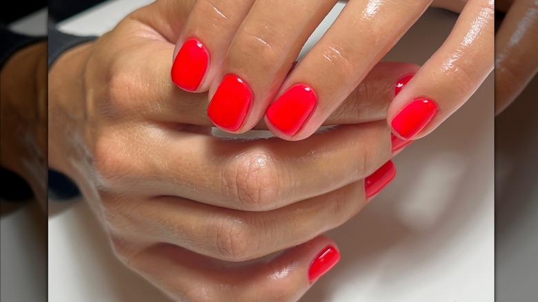 Femme aux ongles rouge vif