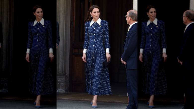 Kate Middleton portant une robe à pois bleu foncé avec un col blanc lors d'une visite à Bletchley Park en 2019.