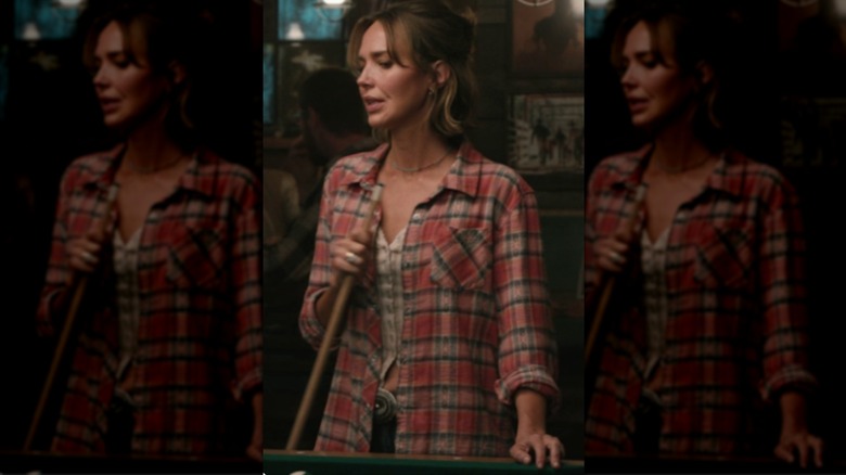 Belle Skinner portant une chemise à carreaux rouge avec un haut beige et un jean