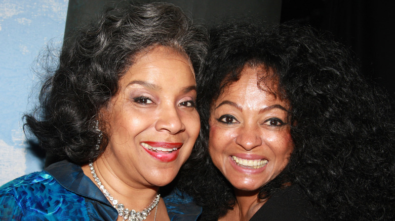 Phylicia Rashad sourit à côté de Diana Ross vêtue d'un chemisier bleu