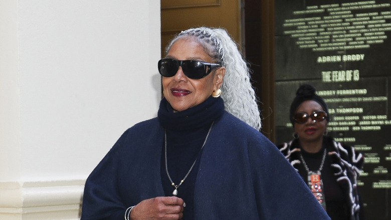 Phylicia Rashad porte ses cheveux en queue de cheval tressée et des lunettes de soleil noires