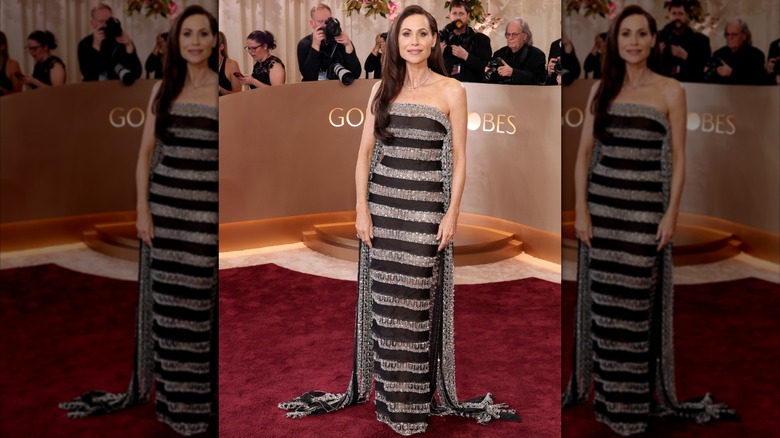 Minnie Driver sur le tapis rouge des Golden Globes vêtue d'une robe à rayures noires et argentées.