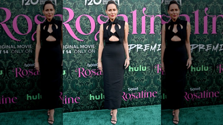 Minnie Driver posant lors d'une première vêtue d'une robe noire avec des découpes autour de la poitrine.