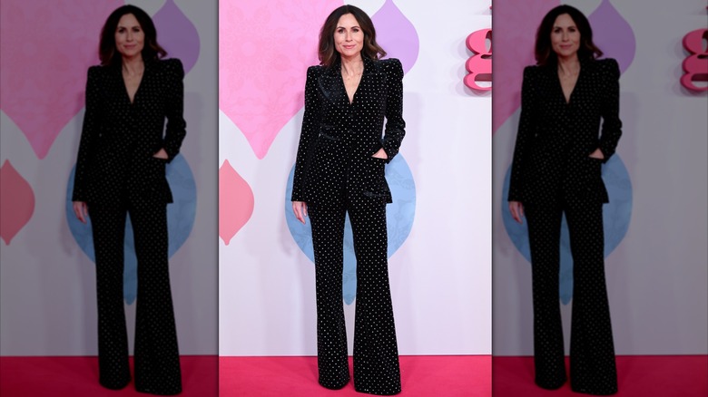 Minnie Driver sur le tapis rouge vêtue d'un costume à pois noir et blanc.
