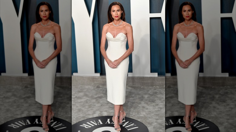 Minnie Driver posant lors d'un événement vêtue d'une simple robe blanche sans bretelles.