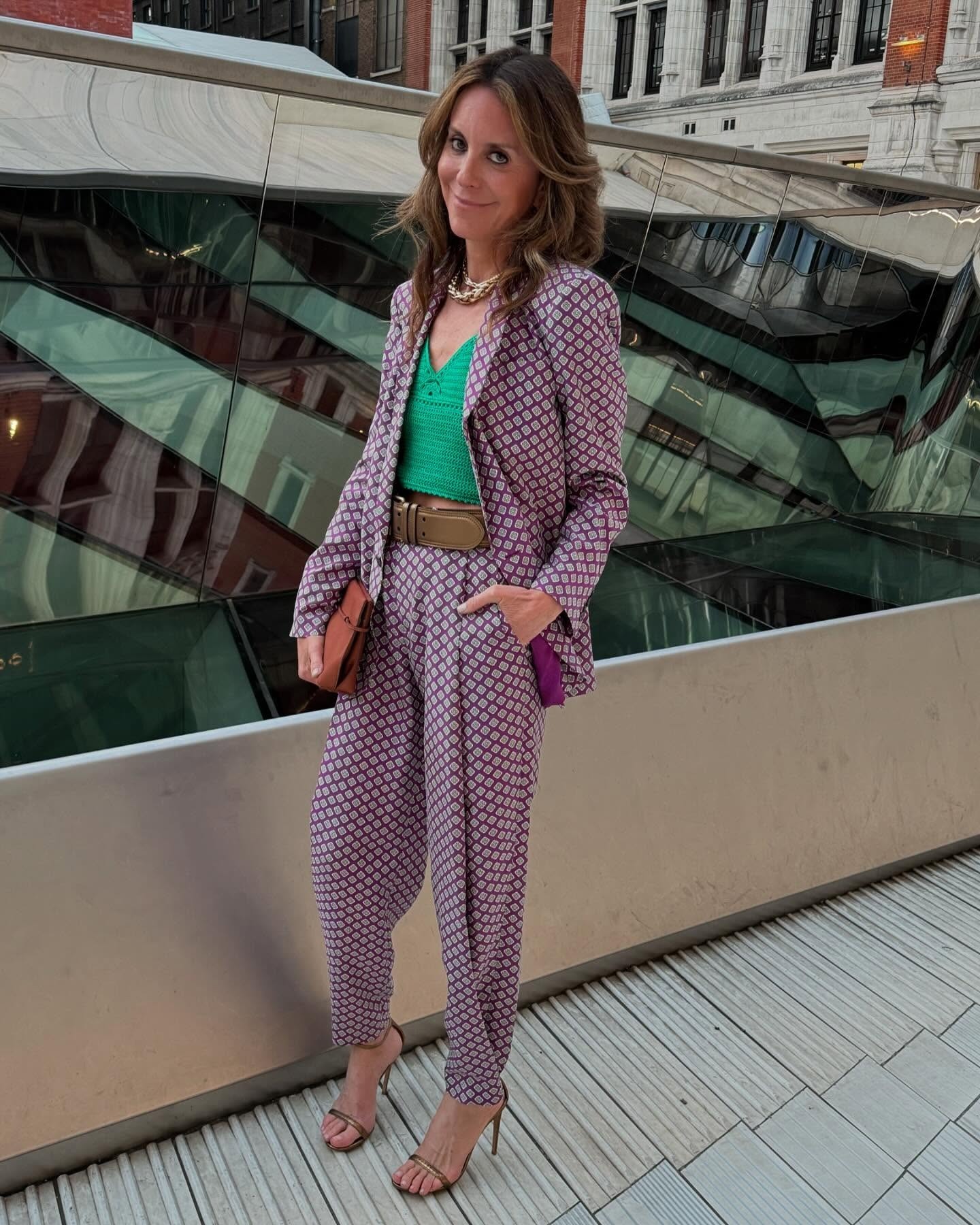 Alison Loehnis dans un tailleur-pantalon imprimé et des sandales à lanières.